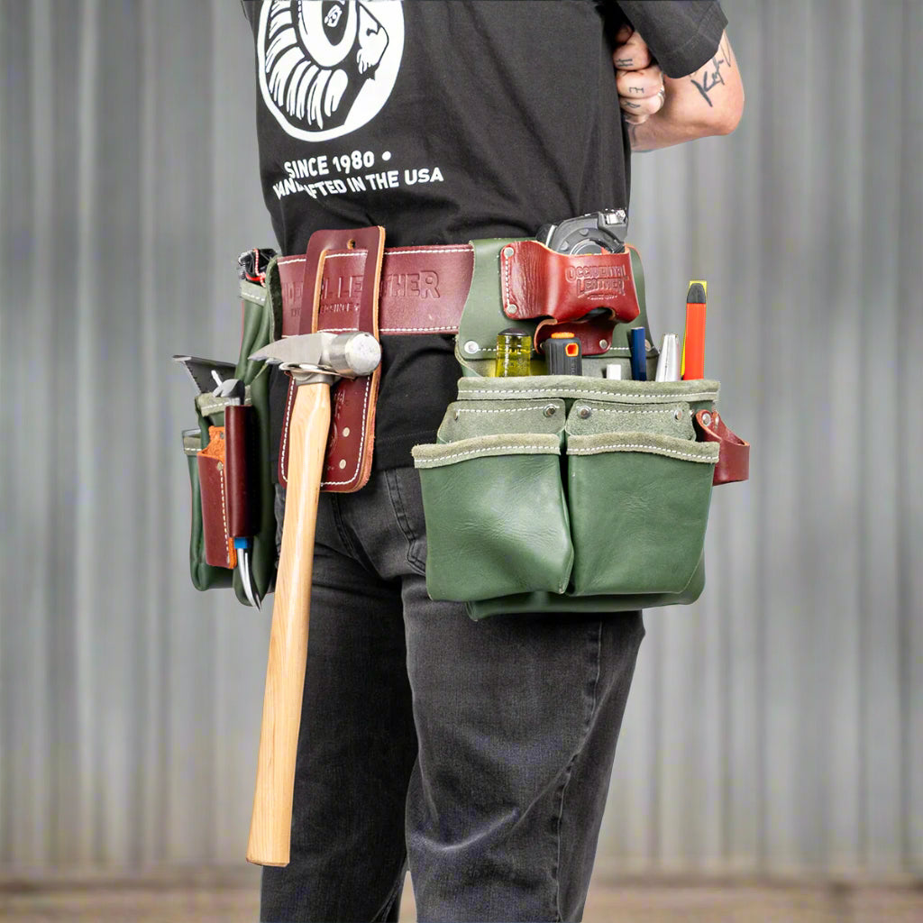 Green 5080DB Occidental Leather tool belt with tools on a builder against a metal corrugated wall
