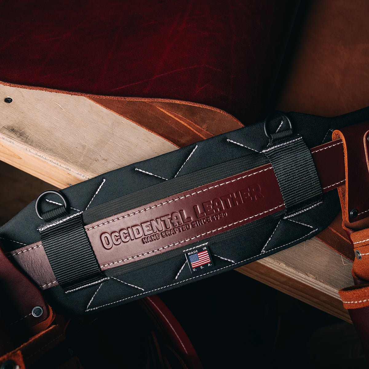 ProFORMANCE belt, black with oxyred leather on wood table with leather hide