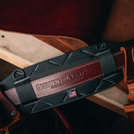 ProFORMANCE belt, black with oxyred leather on wood table with leather hide